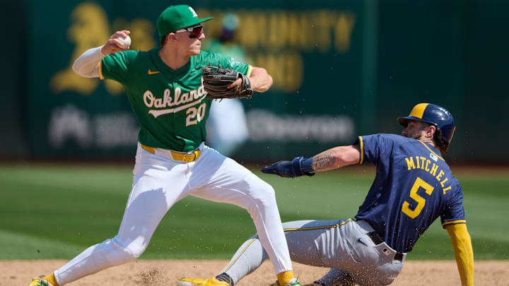 Aug 24, 2024; Oakland, California, USA; Oakland Athletics infielder Zack Gelof (20) throws the ball to first base as Milwaukee Brewers outfielder Garrett Mitchell (5) slides into second base during the sixth inning at Oakland-Alameda County Coliseum. Mandatory Credit: Robert Edwards-Imagn Images