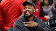 Oct 10, 2025; Portland, Oregon, USA;  Portland Trail Blazers guard Damian Lillard  (0) smiles while sitting on the bench before the Trail Blazers plays Sacramento Kings at Moda Center. Mandatory Credit: Jaime Valdez-Imagn Images