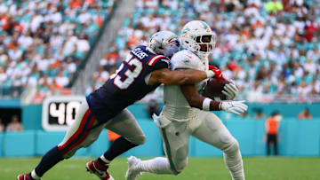 Nov 24, 2024; Miami Gardens, Florida, USA; Miami Dolphins tight end Jonnu Smith (9) runs with the football against New England Patriots linebacker Christian Elliss (53) during the second quarter at Hard Rock Stadium. Mandatory Credit: Sam Navarro-Imagn Images