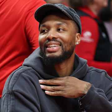 Oct 10, 2025; Portland, Oregon, USA;  Portland Trail Blazers guard Damian Lillard  (0) smiles while sitting on the bench before the Trail Blazers plays Sacramento Kings at Moda Center. Mandatory Credit: Jaime Valdez-Imagn Images