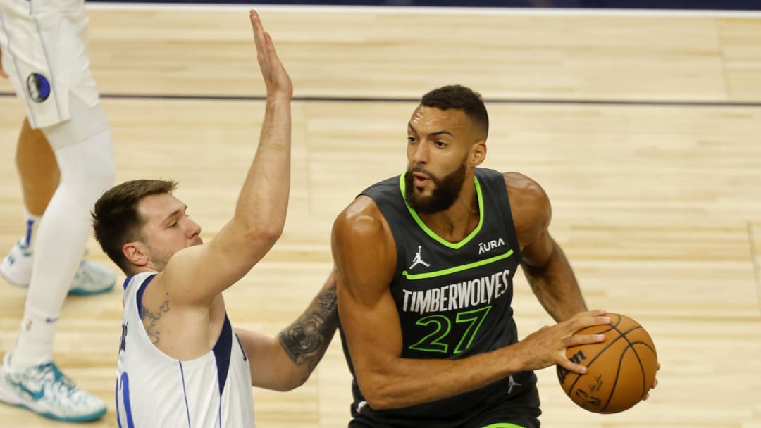 May 30, 2024; Minneapolis, Minnesota, USA; Minnesota Timberwolves center Rudy Gobert (27) looks to pass against Dallas Mavericks guard Luka Doncic (77) during the first quarter in game five of the western conference finals for the 2024 NBA playoffs at Target Center. Mandatory Credit: Bruce Kluckhohn-USA TODAY Sports