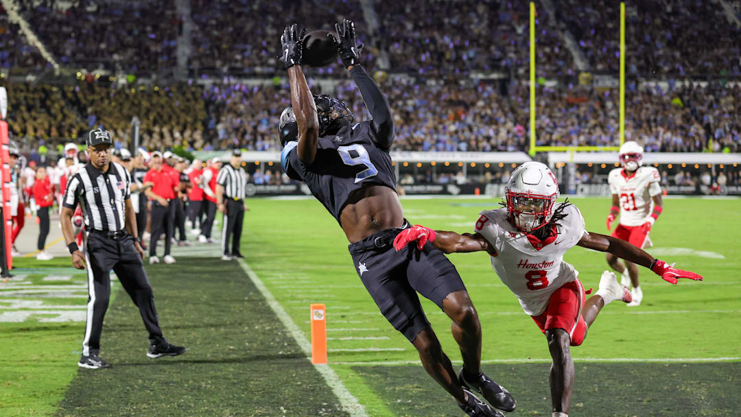 Nov 7, 2025; Orlando, Florida, USA; UCF Knights wide receiver DJ Black (9) jumps to catch a pass in front of Houston Cougars defensive back Kentrell Webb (8) during the first quarter at Acrisure Bounce House. Mandatory Credit: Mike Watters-Imagn Images