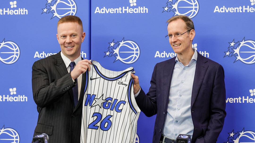 Jun 18, 2026; Orlando, FL, USA; Orlando Magic President of Basketball Operations Jeff Weltman (right) presents new head coach Sean Sweeney with a number 26 jersey before a press conference at AdventHealth Training Center. Mandatory Credit: Mike Watters-Imagn Images