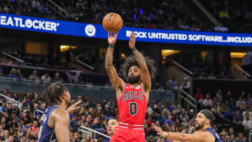 Feb 10, 2024; Orlando, Florida, USA; Chicago Bulls guard Coby White (0) shoots the ball against Orlando Magic center Wendell Carter Jr. (34) and guard Jalen Suggs (4) during the second half at KIA Center. Mandatory Credit: Mike Watters-USA TODAY Sports