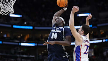 Mar 21, 2024; Salt Lake City, UT, USA; Samford Bulldogs forward Achor Achor (14) dunks against Kansas Jayhawks guard Nicolas Timberlake (25) during the second half in the first round of the 2024 NCAA Tournament at Vivint Smart Home Arena-Delta Center. Mandatory Credit: Rob Gray-Imagn Images