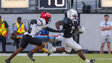 Oct 12, 2024; Orlando, Florida, USA; UCF Knights running back RJ Harvey (7) runs the ball as Cincinnati Bearcats defensive back Logan Wilson (13) moves in during the second half at FBC Mortgage Stadium. Mandatory Credit: Mike Watters-Imagn Images