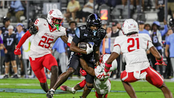 Nov 7, 2025; Orlando, Florida, USA; UCF Knights tight end Dylan Wade (0) is tackled by Houston Cougars defensive back Kentrell Webb (8) during the first quarter at Acrisure Bounce House. Mandatory Credit: Mike Watters-Imagn Images