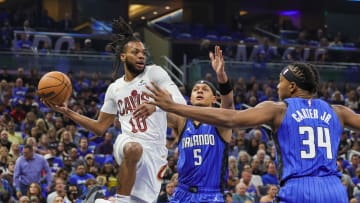 May 3, 2024; Orlando, Florida, USA; Cleveland Cavaliers guard Darius Garland (10) passes the ball between Orlando Magic forward Paolo Banchero (5) and center Wendell Carter Jr. (34) during the first quarter of game six of the first round for the 2024 NBA playoffs at Kia Center. Mandatory Credit: Mike Watters-USA TODAY Sports