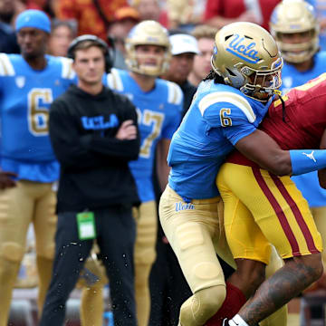 Nov 18, 2023; Los Angeles, California, USA; UCLA Bruins defensive back John Humphrey (6) tackles USC Trojans wide receiver Brenden Rice (2) during the first quarter at United Airlines Field at Los Angeles Memorial Coliseum. Mandatory Credit: Jason Parkhurst-Imagn Images