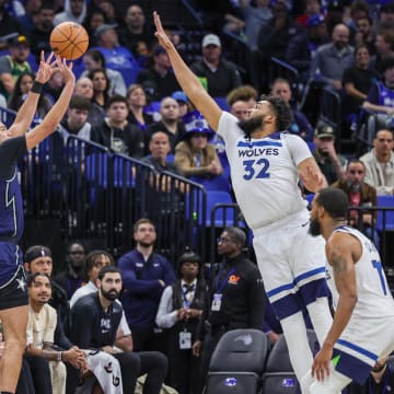 Orlando Magic guard Anthony Black (0) shoots a three-point basket against Minnesota Timberwolves center Karl-Anthony Towns (32) during the second quarter at KIA Center. 