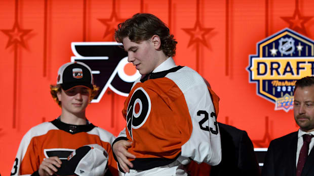 Philadelphia Flyers draft pick Oliver Bonk puts on his sweater after being selected with the 22nd pick of the 2023 NHL Draf