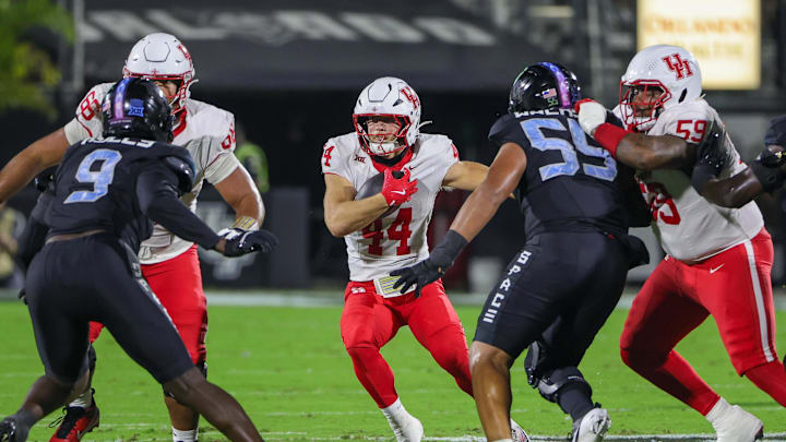 Nov 7, 2025; Orlando, Florida, USA; Houston Cougars running back Dean Connors (44) runs the ball as UCF Knights defensive tackle John Walker (55) moves in during the first quarter at Acrisure Bounce House. Mandatory Credit: Mike Watters-Imagn Images