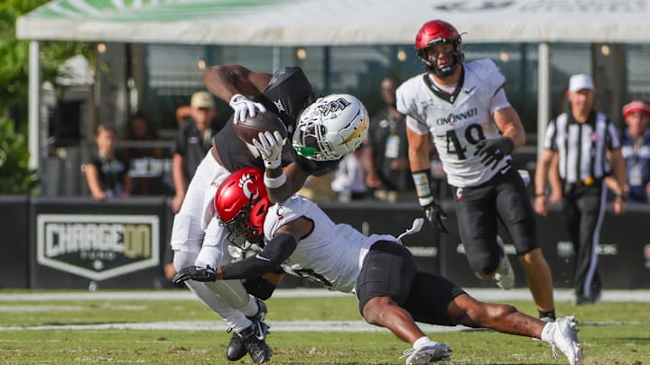 Oct 12, 2024; Orlando, Florida, USA; UCF Knights wide receiver Kobe Hudson (2) is tackled by Cincinnati Bearcats defensive back Derrick Canteen (10) during the second quarter at FBC Mortgage Stadium. Mandatory Credit: Mike Watters-Imagn Images Oct 12, 2024; Orlando, Florida, USA; UCF Knights wide receiver Kobe Hudson (2) is tackled by Cincinnati Bearcats defensive back Derrick Canteen (10) during the second quarter at FBC Mortgage Stadium. Mandatory Credit: Mike Watters-Imagn Images