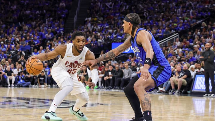 May 3, 2024; Orlando, Florida, USA; Cleveland Cavaliers guard Donovan Mitchell (45) handles the ball against Orlando Magic forward Paolo Banchero (5) during the second half of game six of the first round for the 2024 NBA playoffs at Kia Center. Mandatory Credit: Mike Watters-USA TODAY Sports