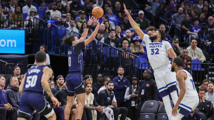 Orlando Magic guard Anthony Black (0) shoots a three-point basket against Minnesota Timberwolves center Karl-Anthony Towns (32) during the second quarter at KIA Center. 