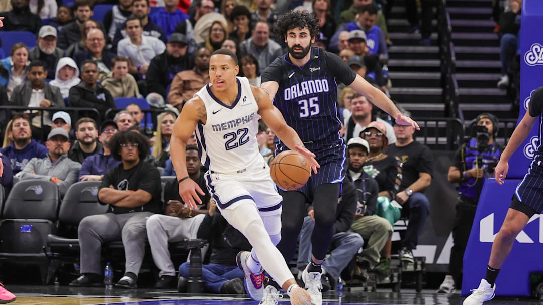 Feb 21, 2025; Orlando, Florida, USA; Memphis Grizzlies guard Desmond Bane (22) moves the ball in front of Orlando Magic center Goga Bitadze (35) during the second quarter at Kia Center. Mandatory Credit: Mike Watters-Imagn Images