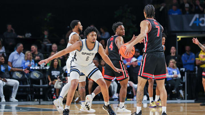 Jan 18, 2025; Orlando, Florida, USA; UCF Knights guard Dallan Coleman (6) defends Houston Cougars guard Milos Uzan (7) during the first half at Addition Financial Arena. Mandatory Credit: Mike Watters-Imagn Images