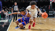 Jan 5, 2025; Orlando, Florida, USA; UCF Knights guard Mikey Williams (1) and Kansas Jayhawks guard David Coit (8) chase a loose ball during the second half at Addition Financial Arena. Mandatory Credit: Mike Watters-Imagn Images