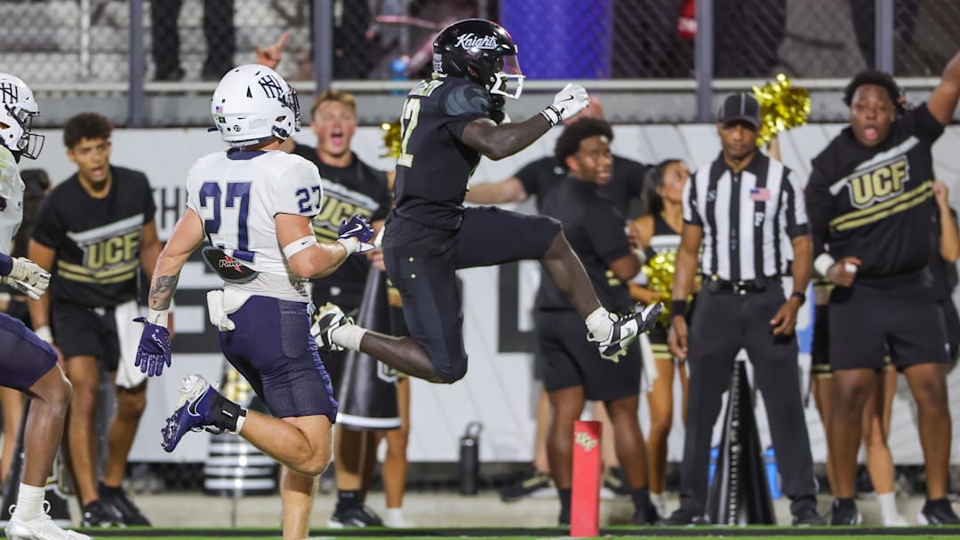 Aug 29, 2024; Orlando, Florida, USA; UCF Knights running back Myles Montgomery (22) scores a touchdown during the second half against the New Hampshire Wildcats at FBC Mortgage Stadium. Mandatory Credit: Mike Watters-Imagn Images