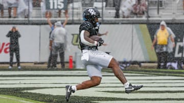 Nov 2, 2024; Orlando, Florida, USA; UCF Knights running back RJ Harvey (7) scores a touchdown against the Arizona Wildcats during the first quarter at FBC Mortgage Stadium. Mandatory Credit: Mike Watters-Imagn Images