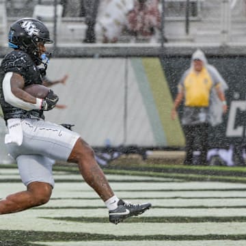 Nov 2, 2024; Orlando, Florida, USA; UCF Knights running back RJ Harvey (7) scores a touchdown against the Arizona Wildcats during the first quarter at FBC Mortgage Stadium. Mandatory Credit: Mike Watters-Imagn Images