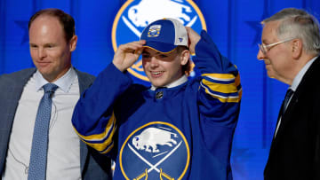 Jun 28, 2023; Nashville, Tennessee, USA; Buffalo Sabres draft pick Zach Benson puts on his hat after being selected with the thirteenth pick in round one of the 2023 NHL Draft at Bridgestone Arena. Mandatory Credit: Christopher Hanewinckel-USA TODAY Sports