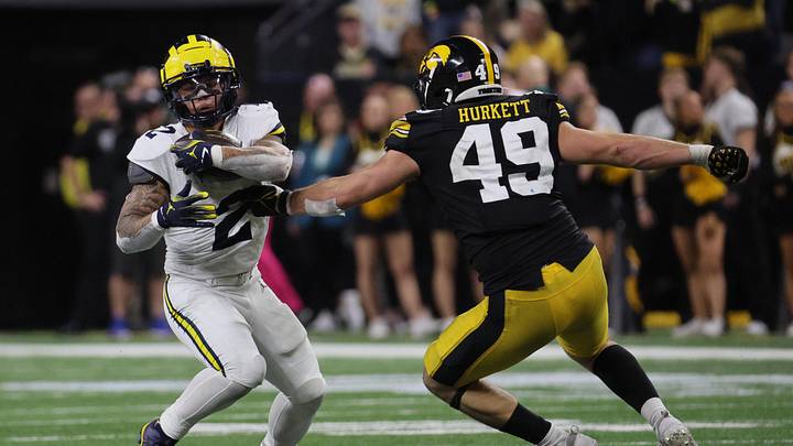 Dec 2, 2023; Indianapolis, IN, USA; Michigan Wolverines running back Blake Corum (2) runs against Iowa Hawkeyes defensive lineman Ethan Hurkett (49) during the second half of the Big Ten Championship game at Lucas Oil Stadium. Mandatory Credit: Trevor Ruszkowski-Imagn Images