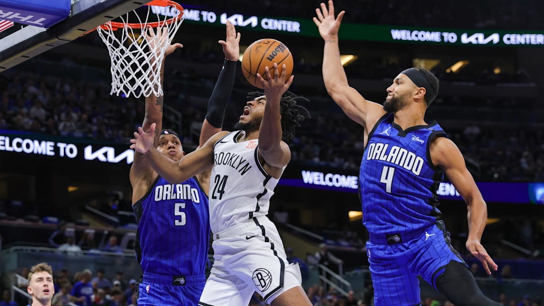 Oct 25, 2024; Orlando, Florida, USA; Brooklyn Nets guard Cam Thomas (24) goes to the basket against Orlando Magic forward Paolo Banchero (5) and guard Jalen Suggs (4) during the second quarter at Kia Center. Mandatory Credit: Mike Watters-Imagn Images