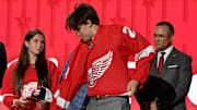 Jun 28, 2023; Nashville, Tennessee, USA; Detroit Red Wings draft pick Axel Sandin Pellikka puts on his sweater after being selected with the seventeenth pick in round one of the 2023 NHL Draft at Bridgestone Arena. Mandatory Credit: Christopher Hanewinckel-Imagn Images