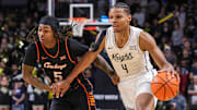 Mar 5, 2025; Orlando, Florida, USA; UCF Knights guard Keyshawn Hall (4) drives past Oklahoma State Cowboys guard Khalil Brantley (5) during the second half at Addition Financial Arena. Mandatory Credit: Mike Watters-Imagn Images