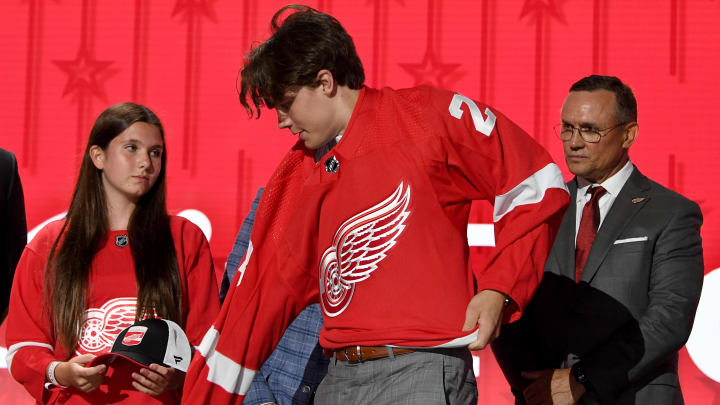 Jun 28, 2023; Nashville, Tennessee, USA; Detroit Red Wings draft pick Axel Sandin Pellikka puts on his sweater after being selected with the seventeenth pick in round one of the 2023 NHL Draft at Bridgestone Arena. Mandatory Credit: Christopher Hanewinckel-USA TODAY Sports