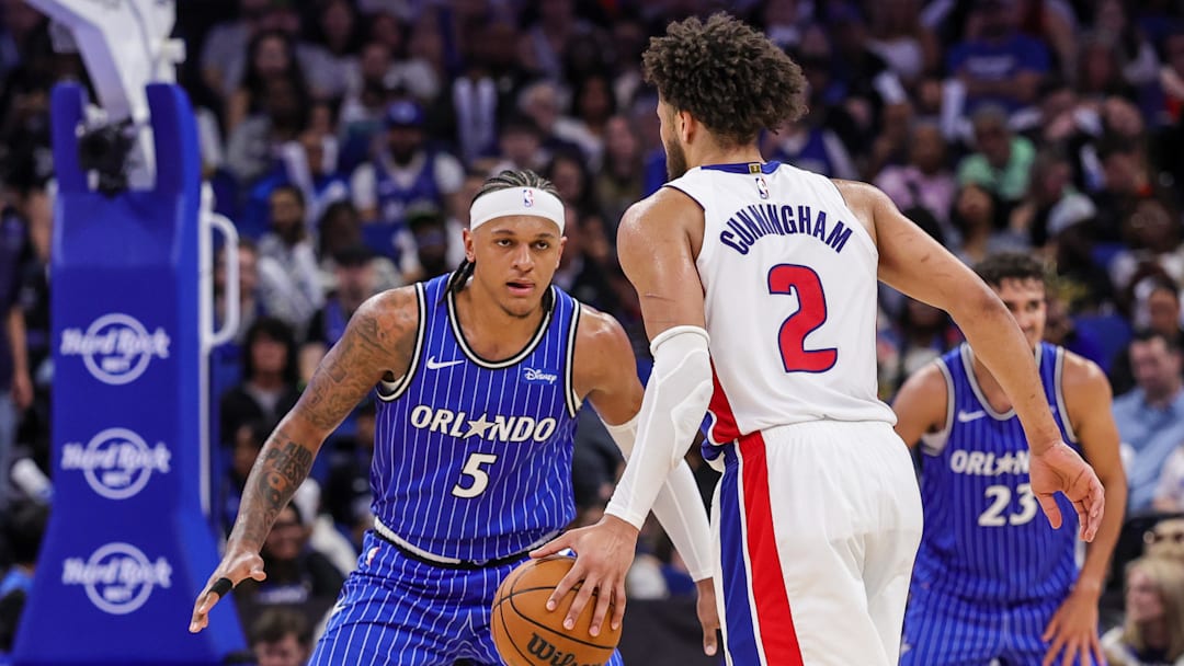 Mar 1, 2026; Orlando, Florida, USA; Orlando Magic forward Paolo Banchero (5) defends Detroit Pistons guard Cade Cunningham (2) during the second half at Kia Center. Mandatory Credit: Mike Watters-Imagn Images