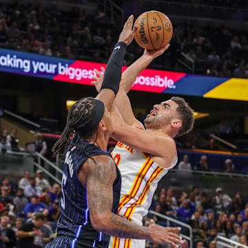 Apr 8, 2025; Orlando, Florida, USA; Atlanta Hawks forward Georges Niang (20) shoots against Orlando Magic forward Paolo Banchero (5) during the second quarter at Kia Center. Mandatory Credit: Mike Watters-Imagn Images
