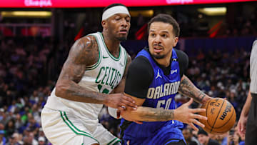 Apr 9, 2025; Orlando, Florida, USA; Orlando Magic guard Cole Anthony (50) drives past Boston Celtics forward Torrey Craig (12) during the second half at Kia Center. Mandatory Credit: Mike Watters-Imagn Images