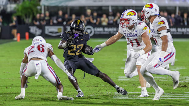 UCF Knights running back Myles Montgomery (22) runs the ball as Kansas Jayhawks cornerback Jalen Todd (26).