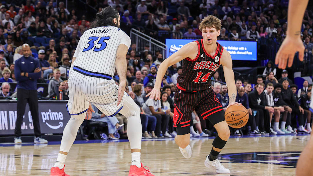 Dec 1, 2025; Orlando, Florida, USA; Chicago Bulls forward Matas Buzelis (14) drives against Orlando Magic center Goga Bitadze (35) during the second half at Kia Center. Mandatory Credit: Mike Watters-Imagn Images
