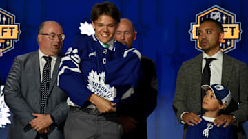 Jun 28, 2023; Nashville, Tennessee, USA; Toronto Maple Leafs draft pick Easton Cowan puts on his sweater after being selected with the twenty eighth pick in round one of the 2023 NHL Draft at Bridgestone Arena. Mandatory Credit: Christopher Hanewinckel-Imagn Images