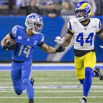 Jan 14, 2024; Detroit, Michigan, USA; Detroit Lions wide receiver Amon-Ra St. Brown (14) runs from Los Angeles Rams cornerback Ahkello Witherspoon (44) during the second half of a 2024 NFC wild card game at Ford Field. Mandatory Credit: David Reginek-Imagn Images