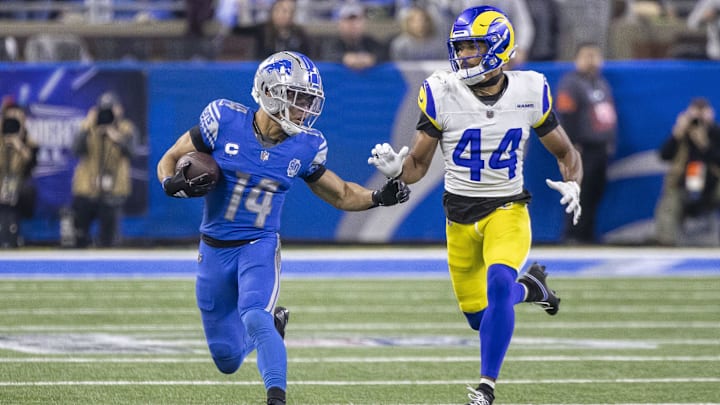 Jan 14, 2024; Detroit, Michigan, USA; Detroit Lions wide receiver Amon-Ra St. Brown (14) runs from Los Angeles Rams cornerback Ahkello Witherspoon (44) during the second half of a 2024 NFC wild card game at Ford Field. Mandatory Credit: David Reginek-Imagn Images