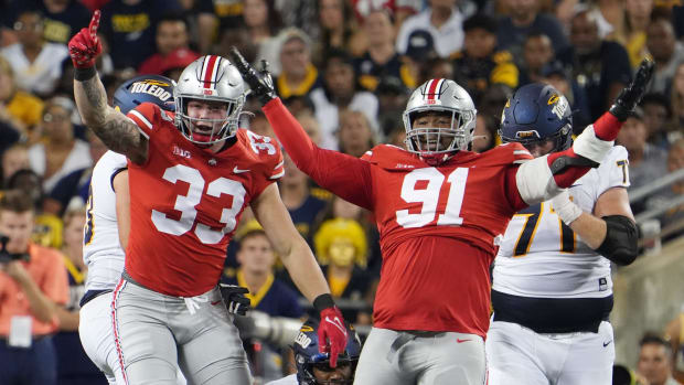 Two defensive linemen celebrate a sack.