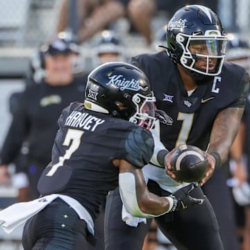 Aug 29, 2024; Orlando, Florida, USA; UCF Knights quarterback KJ Jefferson (1) hands off to running back RJ Harvey (7) during the first quarter against the New Hampshire Wildcats at FBC Mortgage Stadium. Mandatory Credit: Mike Watters-Imagn Images