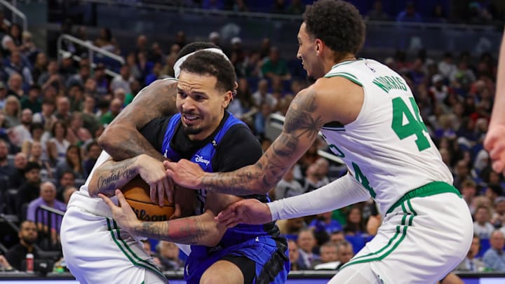 Apr 9, 2025; Orlando, Florida, USA; Orlando Magic guard Cole Anthony (50), Boston Celtics forward Miles Norris (44), and forward Torrey Craig (12) battle for the ball during the second half at Kia Center.
