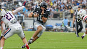Nov 2, 2024; Orlando, Florida, USA; UCF Knights quarterback Dylan Rizk (10) carries the ball against the Arizona Wildcats during the first quarter at FBC Mortgage Stadium. Mandatory Credit: Mike Watters-Imagn Images