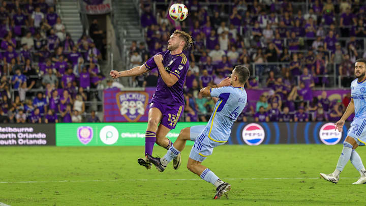 Oct 19, 2024; Orlando, Florida, USA; Orlando City forward Duncan McGuire (13) heads the ball in front of Atlanta United midfielder Bartosz Slisz (6) during the second half at Inter&Co Stadium. Mandatory Credit: Mike Watters-Imagn Images