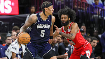 Apr 7, 2024; Orlando, Florida, USA; Orlando Magic forward Paolo Banchero (5) moves the ball around Chicago Bulls guard Coby White (0) during the second half at KIA Center. Mandatory Credit: Mike Watters-Imagn Images