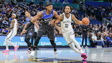 Nov 14, 2025; Orlando, Florida, USA; Brooklyn Nets center Nic Claxton (33) drives to the basket around Orlando Magic center Wendell Carter Jr. (34) during the first quarter at Kia Center. Mandatory Credit: Mike Watters-Imagn Images