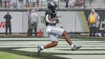 Nov 2, 2024; Orlando, Florida, USA; UCF Knights running back RJ Harvey (7) scores a touchdown against the Arizona Wildcats during the first quarter at FBC Mortgage Stadium. Mandatory Credit: Mike Watters-Imagn Images