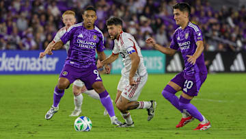 Mar 1, 2025; Orlando, Florida, USA; Toronto FC midfielder Jonathan Osorio (21) moves the ball against Orlando City forward Luis Muriel (9) and midfielder Eduard Atuesta (20) during the second half at Inter&Co Stadium. Mandatory Credit: Mike Watters-Imagn Images