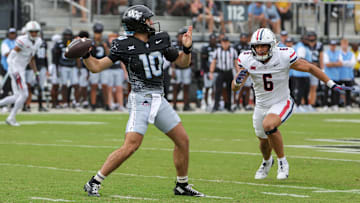 Nov 2, 2024; Orlando, Florida, USA; UCF Knights quarterback Dylan Rizk (10) throws a pass against Arizona Wildcats linebacker Taye Brown (6) during the first quarter at FBC Mortgage Stadium. Mandatory Credit: Mike Watters-Imagn Images