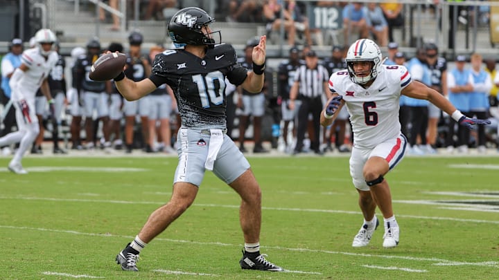 Nov 2, 2024; Orlando, Florida, USA; UCF Knights quarterback Dylan Rizk (10) throws a pass against Arizona Wildcats linebacker Taye Brown (6) during the first quarter at FBC Mortgage Stadium. Mandatory Credit: Mike Watters-Imagn Images